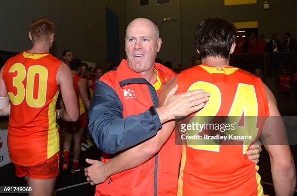 Coach Rodney Eade of the Suns celebrates victory with David Swallow after the round 11 AFL match between the Gold Coast Suns and the West Coast...