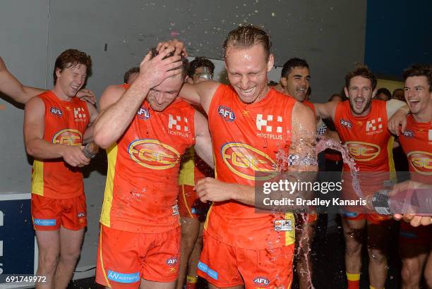 Will Brodie and Pearce Hanley of the Suns are sprayed with gatorade as they celebrate victory after the round 11 AFL match between the Gold Coast...