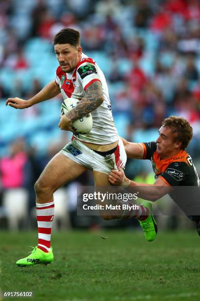 Gareth Widdop of the Dragons is tackled during the round 13 NRL match between the St George Illawarra Dragons and the Wests Tigers at ANZ Stadium on...