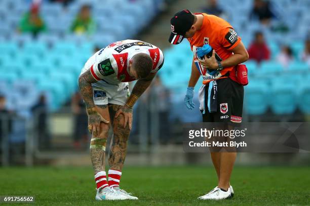Josh Dugan of the Dragons seeks treatment from a trainer after an injury during the round 13 NRL match between the St George Illawarra Dragons and...