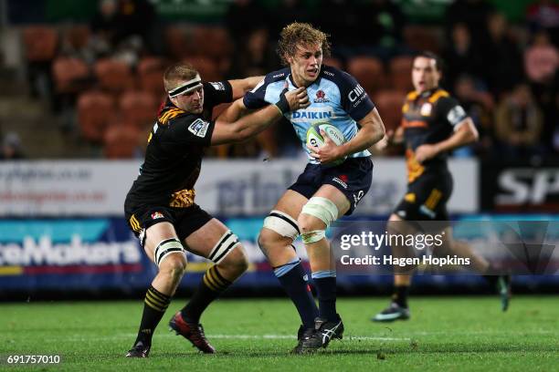 Ned Hanigan of the Waratahs is tackled by Sam Cane of the Chiefs during the round 15 Super Rugby match between the Chiefs and the Waratahs at Waikato...