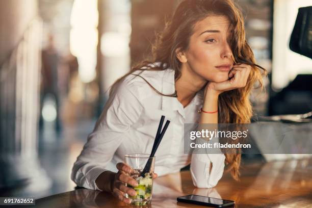 frau trinken cocktail in einer bar - betrunken stock-fotos und bilder