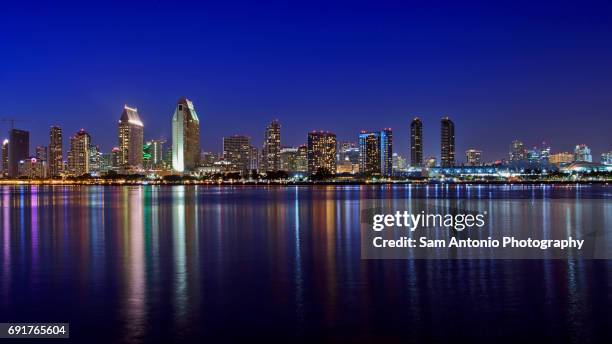 downtown city skyline with reflections in bay water - san diego skyline night stock pictures, royalty-free photos & images