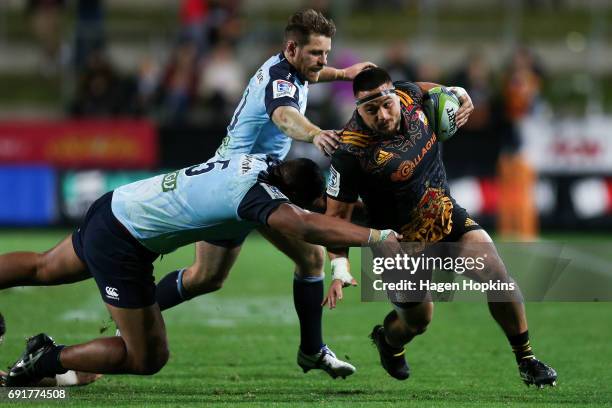 Kane Hames of the Chiefs attempts to beat the defence of Will Skelton and Bernard Foley of the Waratahs during the round 15 Super Rugby match between...