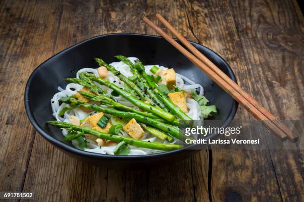 bowl of vegan pad thai with mini green asparagus and tofu - larissa veronesi bildbanksfoton och bilder