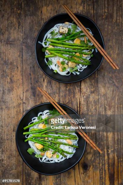 two bowls of vegan pad thai with mini green asparagus and tofu - larissa veronesi stockfoto's en -beelden