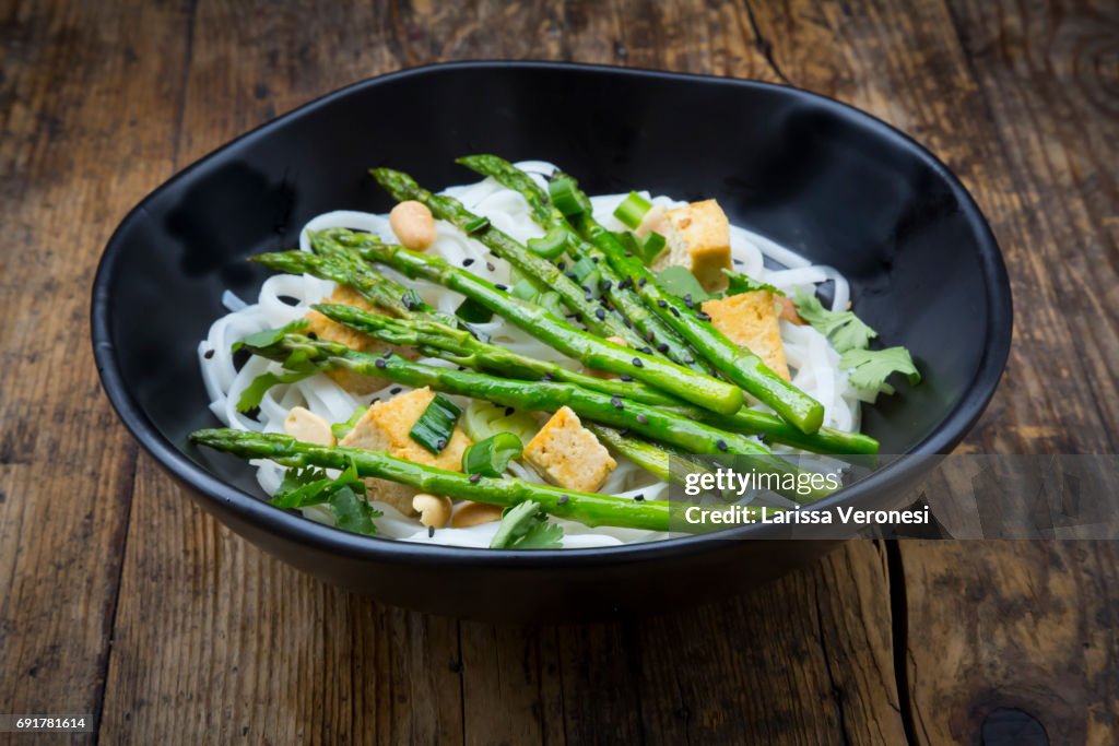Bowl of vegan Pad thai with mini green asparagus and tofu