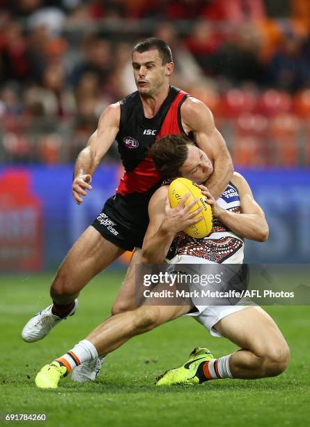 Toby Greene of the Giants is tackled by Brent Stanton of the Bombers during the round 11 AFL match between the Greater Western Sydney Giants and the...