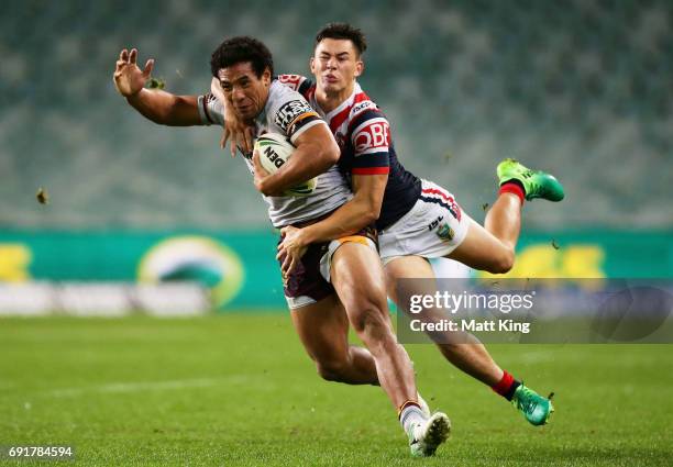 Tautau Moga of the Broncos is tackled by Joseph Manu of the Roosters during the round 13 NRL match between the Sydney Roosters and the Brisbane...