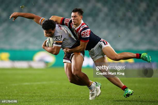 Tautau Moga of the Broncos is tackled by Joseph Manu of the Roosters during the round 13 NRL match between the Sydney Roosters and the Brisbane...