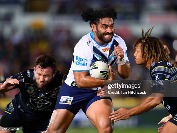 Konrad Hurrell of the Titans is tackled by Gavin Cooper and Ray Thompson of the Cowboys during the round 13 NRL match between the North Queensland...