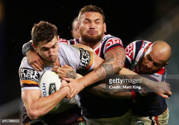 Corey Oates of the Broncos is tackled by Jared Waerea-Hargreaves and Blake Ferguson of the Roosters during the round 13 NRL match between the Sydney...