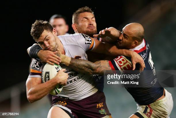 Corey Oates of the Broncos is tackled by Jared Waerea-Hargreaves and Blake Ferguson of the Roosters during the round 13 NRL match between the Sydney...