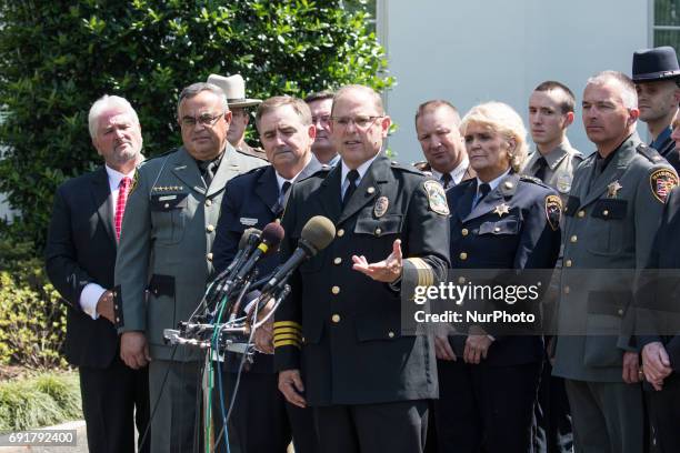 Chuck Canterbury, center, National President of the Fraternal Order of Police, speaks with other law enforcement officials standing with him outside...