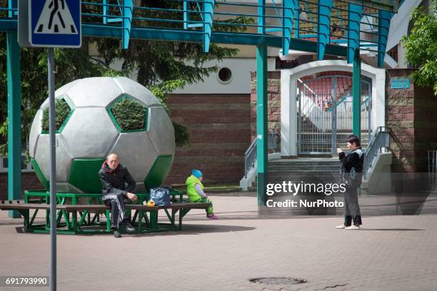 Woman is seen taking a photo with her phone at the entrance of the Brestsky sports complex, the stadium where football club Dinamo Brest plays.