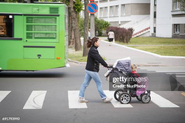 Young woman pushing a buggy with a flat tyre is seen in the center of Brest on 1 June, 2017.