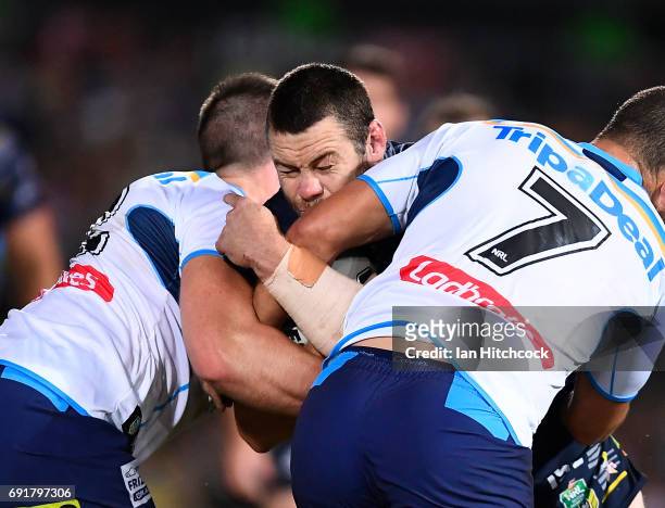 Shaun Fensom of the Cowboys is tackled by Ashley Taylor of the Titans during the round 13 NRL match between the North Queensland Cowboys and the Gold...