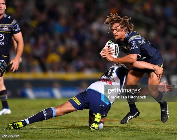 Ray Thompson of the Cowboys is tackled by Ryan James of the Titans during the round 13 NRL match between the North Queensland Cowboys and the Gold...