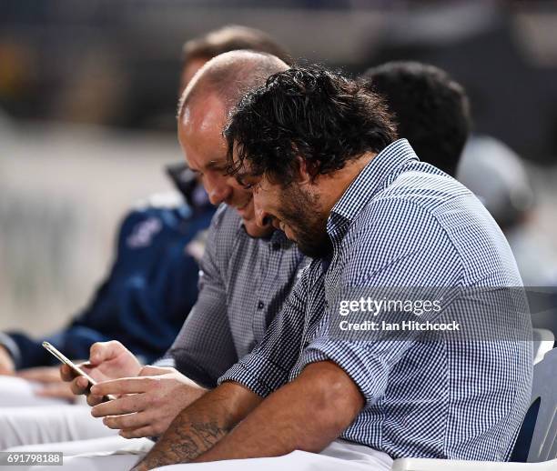 Johnathan Thurston of the Cowboys looks at Matthew Scott's phone during the round 13 NRL match between the North Queensland Cowboys and the Gold...