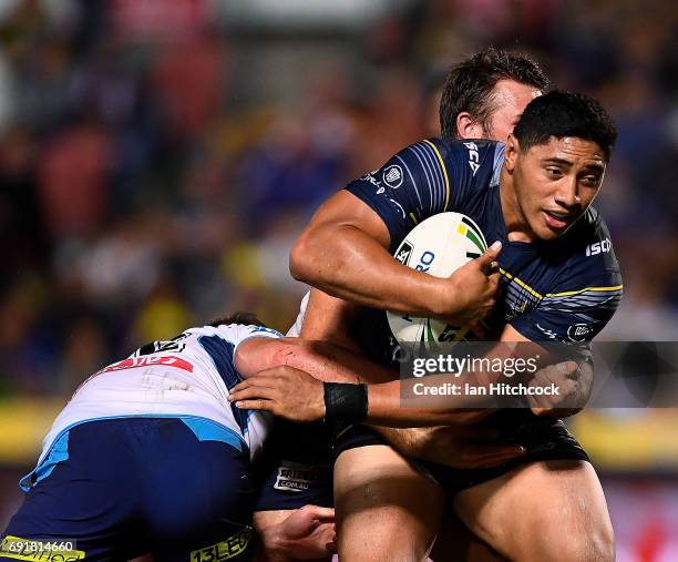 Jason Taumalolo of the Cowboys is tackled by Joe Greenwood of the Titans during the round 13 NRL match between the North Queensland Cowboys and the...