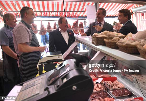 Former Ukip leader Nigel Farage and the party's local candidate Tim Aker talk to a pair of butchers during a General Election campaign visit to...