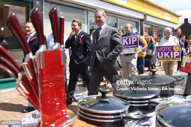 Former Ukip leader Nigel Farage and the party's local candidate Tim Aker pass market stalls in the High Street during a General Election campaign...