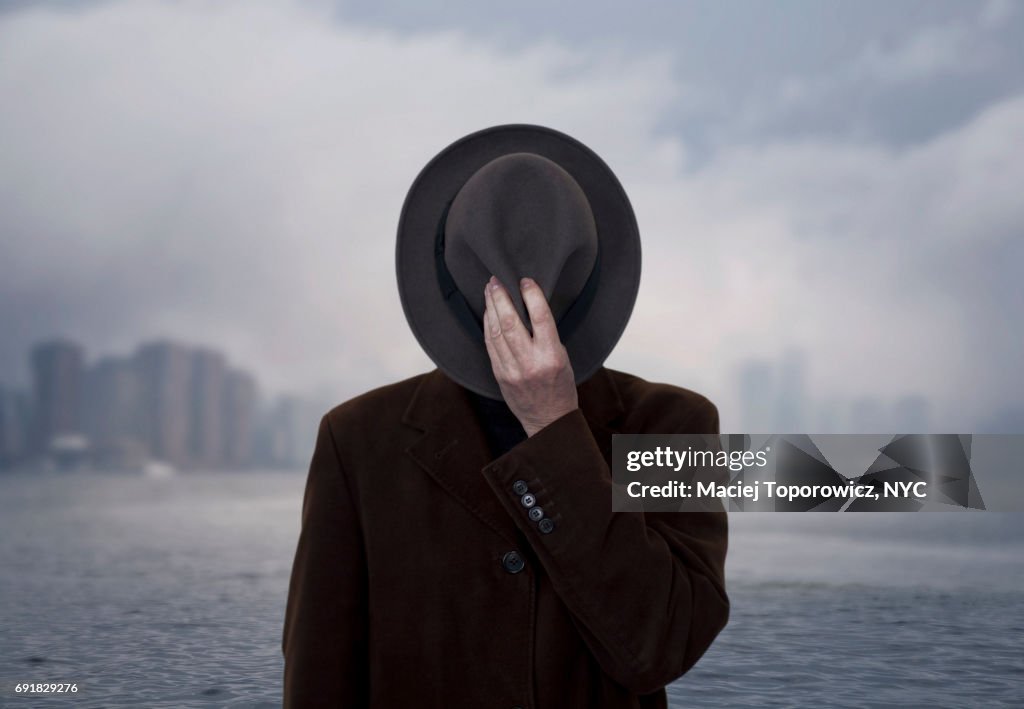 Portrait of a man with face covered by the hat.