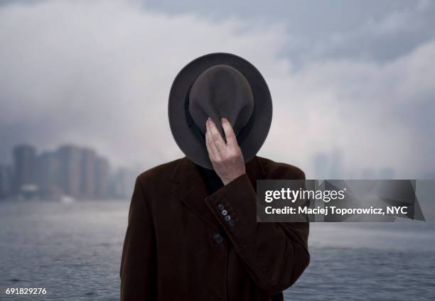 portrait of a man with face covered by the hat. - spion bildbanksfoton och bilder