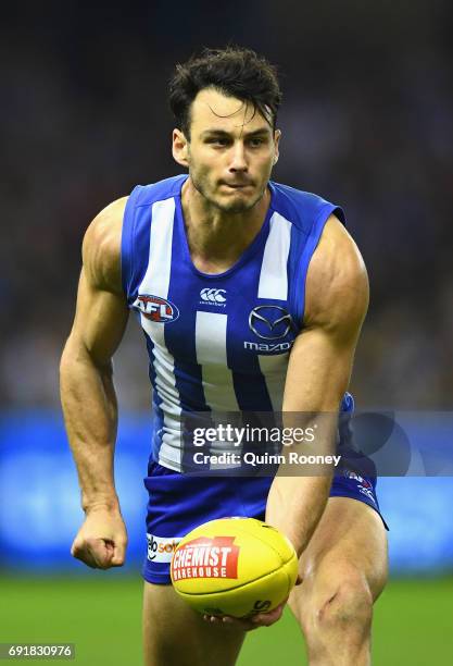 Robbie Tarrant of the Kangaroos handballs during the round 11 AFL match between the North Melbourne Kangaroos and the Richmond Tigers at Etihad...