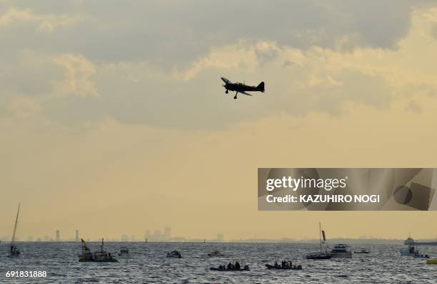 Restored World War II-era Mitsubishi A6M Zero fighter flies over Tokyo Bay during an exhibition as part of the Red Bull Air Race World Championship...