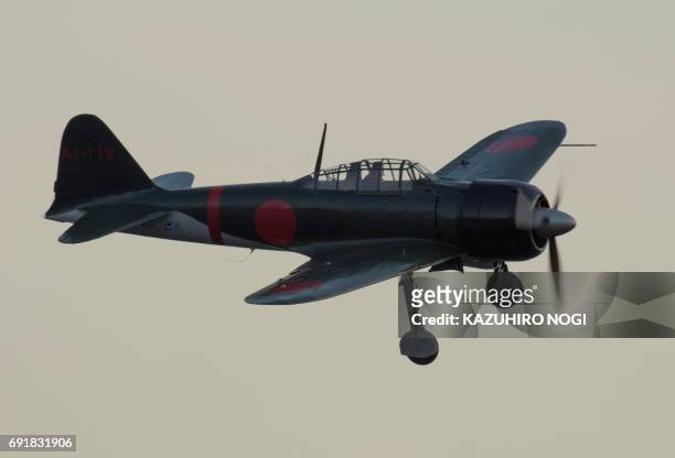 Restored World War II-era Mitsubishi A6M Zero fighter flies over Tokyo Bay during an exhibition as part of the Red Bull Air Race World Championship...