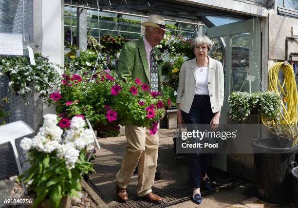 Britain's Prime Minister Theresa May and nursery owner Tom Horsfield walk during an election campaign visit to Horsfields Nursery on June 3, 2017 in...