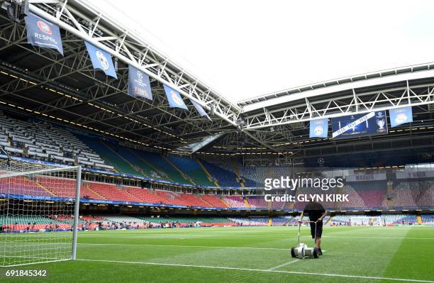 Groundsman puts the finishing touches to the pitch ahead of the UEFA Champions League final football match between Juventus and Real Madrid at The...