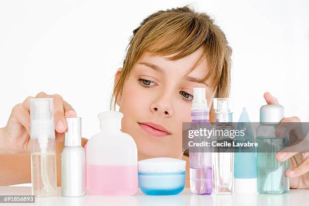 teenager choosing skincare products - facial cleanser stockfoto's en -beelden