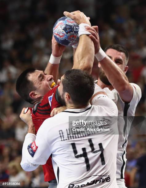 Renato Sulic of Veszprem is challenged by Nikola Karabatic and Luka Karabatic of Paris during the VELUX EHF FINAL4 Semi Final between Telekom...