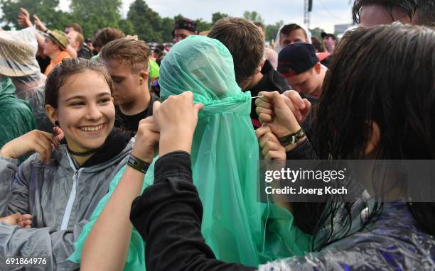 Visitors try to cover from starting heavy rain during the 'Rock Im Park' music festival at Zeppelinfeld on June 3, 2017 in Nuremberg, Germany.