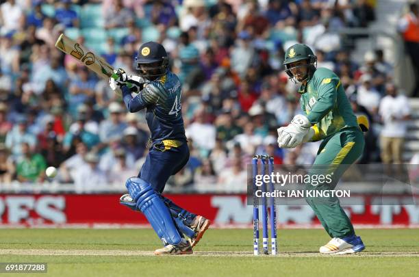 Sri Lankas Upul Tharanga plays a shot as South Africas Quinton de Kock looks on during the ICC Champions Trophy match between South Africa and Sri...