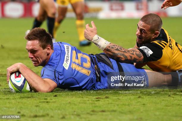 Dane Haylett-Petty of the Force crosses the line for a try against TJ Perenara of the Hurricanes during the round 15 Super Rugby match between the...