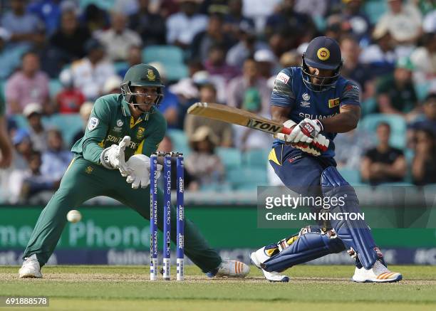 Sri Lankas Kusal Perera plays a shot as South Africas Quinton de Kock looks on during the ICC Champions Trophy match between South Africa and Sri...