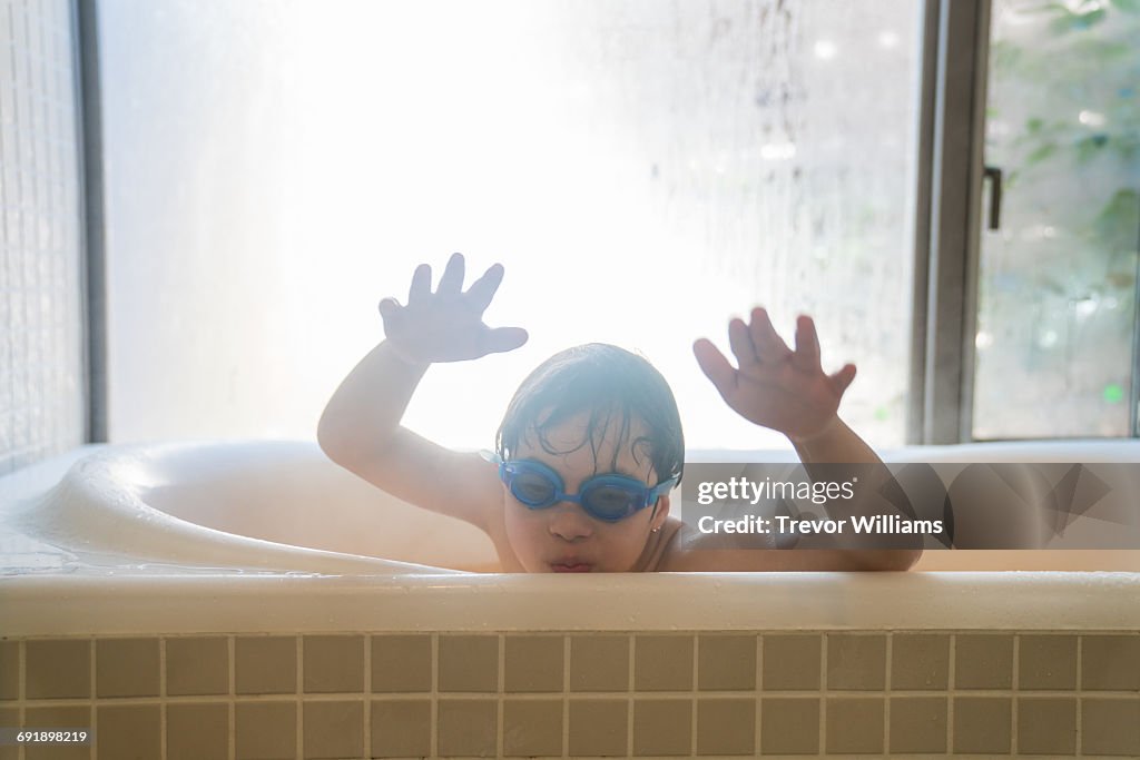 Special needs boy playing in the bath tub