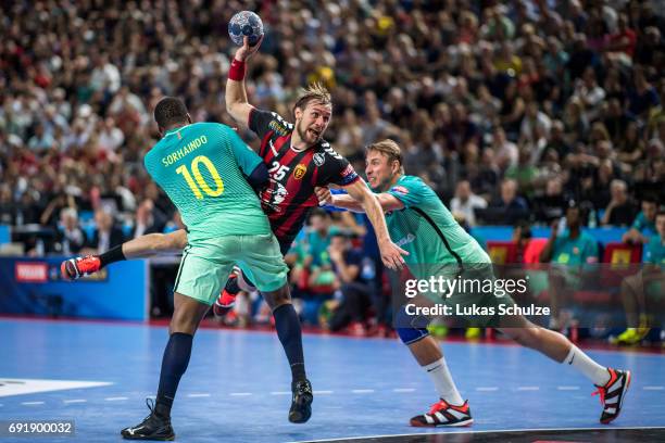 Luka Cindric of Vardar is attacked by Cedric Sorhaindo and Filip Jicha of Barcelona during the VELUX EHF FINAL4 Semi Final match between HC Vardar...