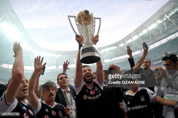 Besiktas' defender Gokhan Gonul holds the trophy as players celebrate their 2016-2017 Turkish league champion title after the Turkish Spor Toto Super...