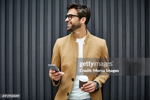Smiling businessman with smart phone and cup Smiling businessman with smart phone and cup