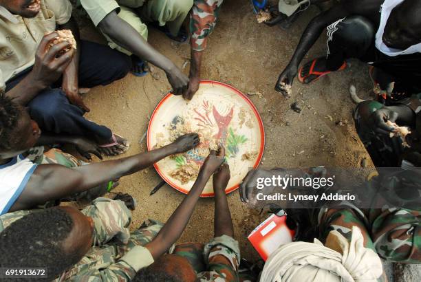 Sudanese government soldiers eat in a prison in Iriba, in northeastern Chad, October 14, 2006. Fierce fighting continues between Sudanese government...