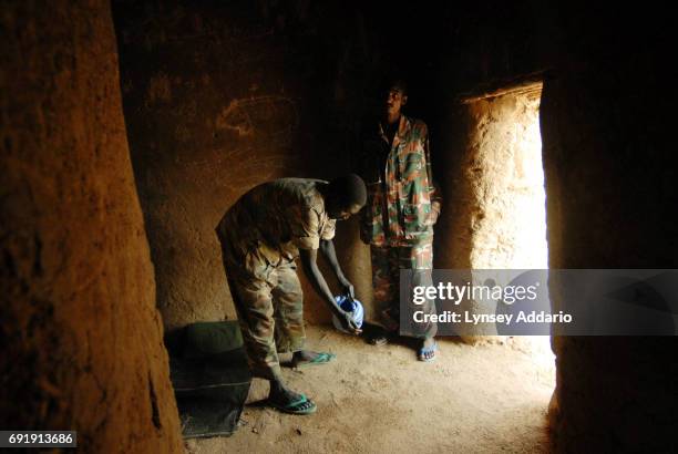 Sudanese government soldiers wash before prayer while being held in a prison in Iriba, in northeastern Chad, October 14, 2006. Fierce fighting...