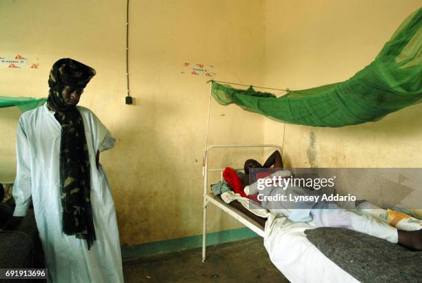 Darfur rebel fans a wounded fellow soldier in a local hospital in Iriba, in northeastern Chad, October 14, 2006. Fierce fighting continues between...