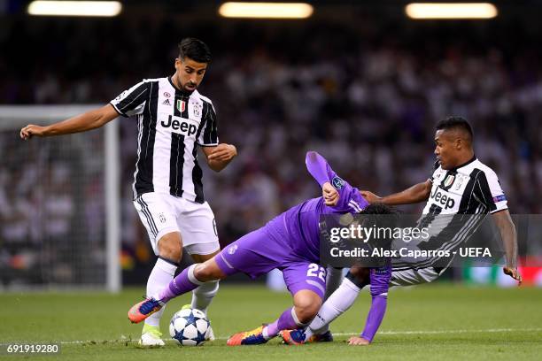 Isco of Real Madrid is fouled by Sami Khedira of Juventus and Alex Sandro of Juventus during the UEFA Champions League Final between Juventus and...