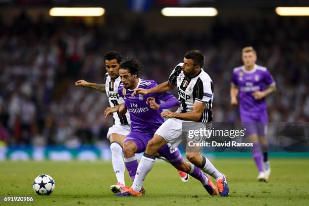 Isco of Real Madrid is fouled by Dani Alves of Juventus and Andrea Barzagli of Juventus during the UEFA Champions League Final between Juventus and...