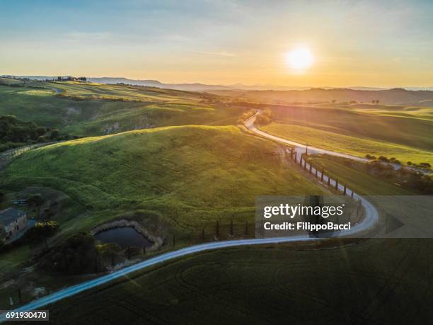 kronkelende weg in toscane - rolling hills sun stockfoto's en -beelden