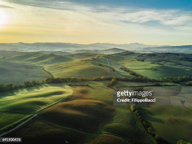 paisaje de tuscany en amanecer con niebla baja - punto de vista de dron fotografías e imágenes de stock